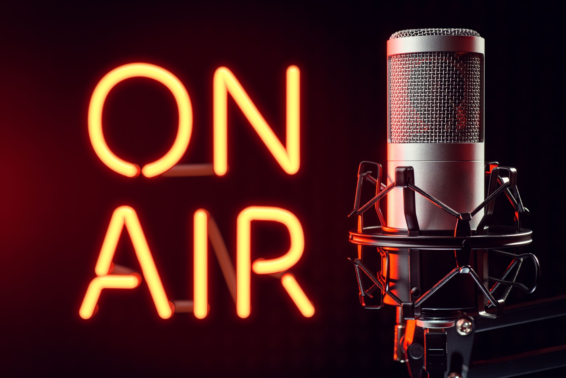 Professional silver microphone with orange illuminated ON AIR neon sign.